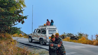 A happy family stepping into a comfortable car with Nepal’s mountains in the background.