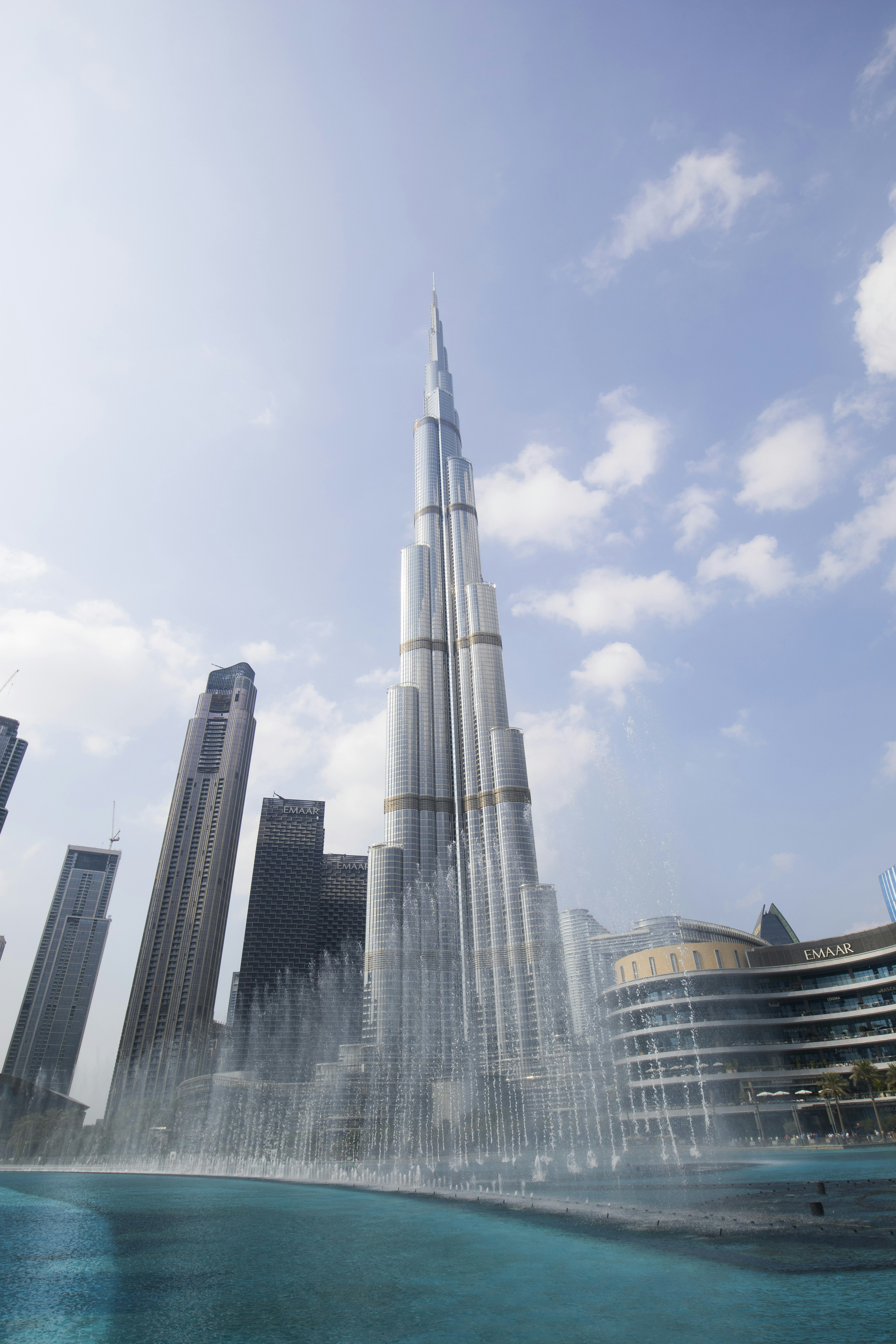 un edificio alto junto al agua con Burj Khalifa al fondo