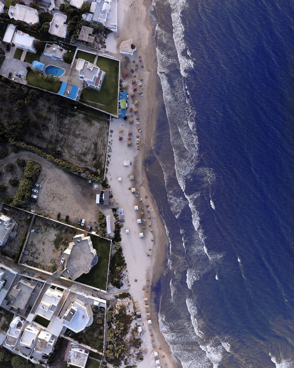 a beach with houses and cars