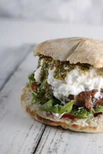 Close-up of a freshly made mortadelli sandwich on Genovese focaccia with vibrant ingredients.