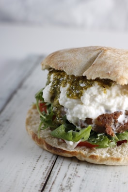 Close-up of a freshly made sandwich with vibrant vegetables and melted cheese on rustic bread