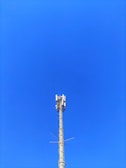 Mobile phone towers standing tall against a clear blue sky.