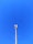 A cellular tower against a clear blue sky. The structure is tall and metallic with multiple antennas attached at the top.