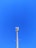 A cellular tower against a clear blue sky. The structure is tall and metallic with multiple antennas attached at the top.