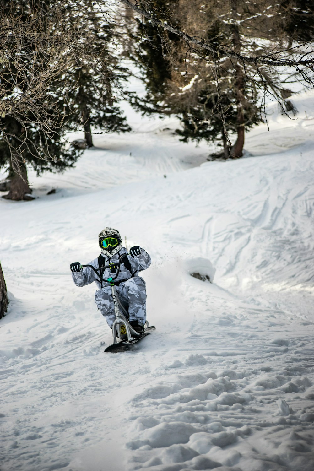 a snowboarder going down a snowy slope