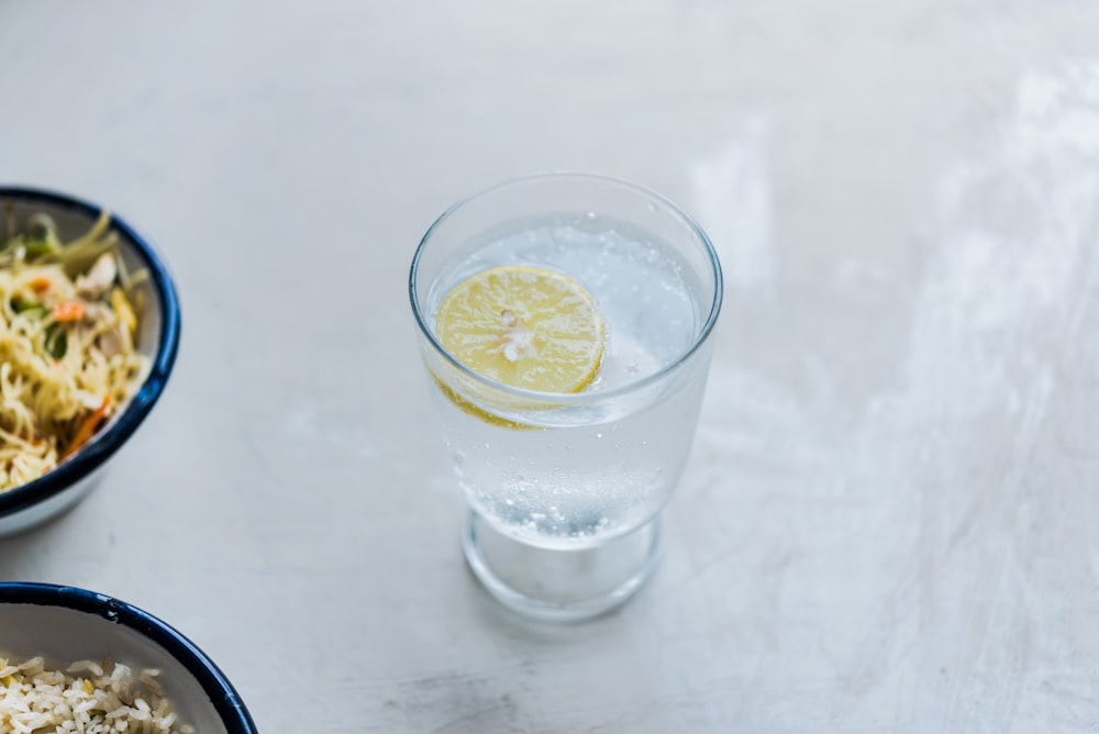 a glass of water with a lemon slice on top