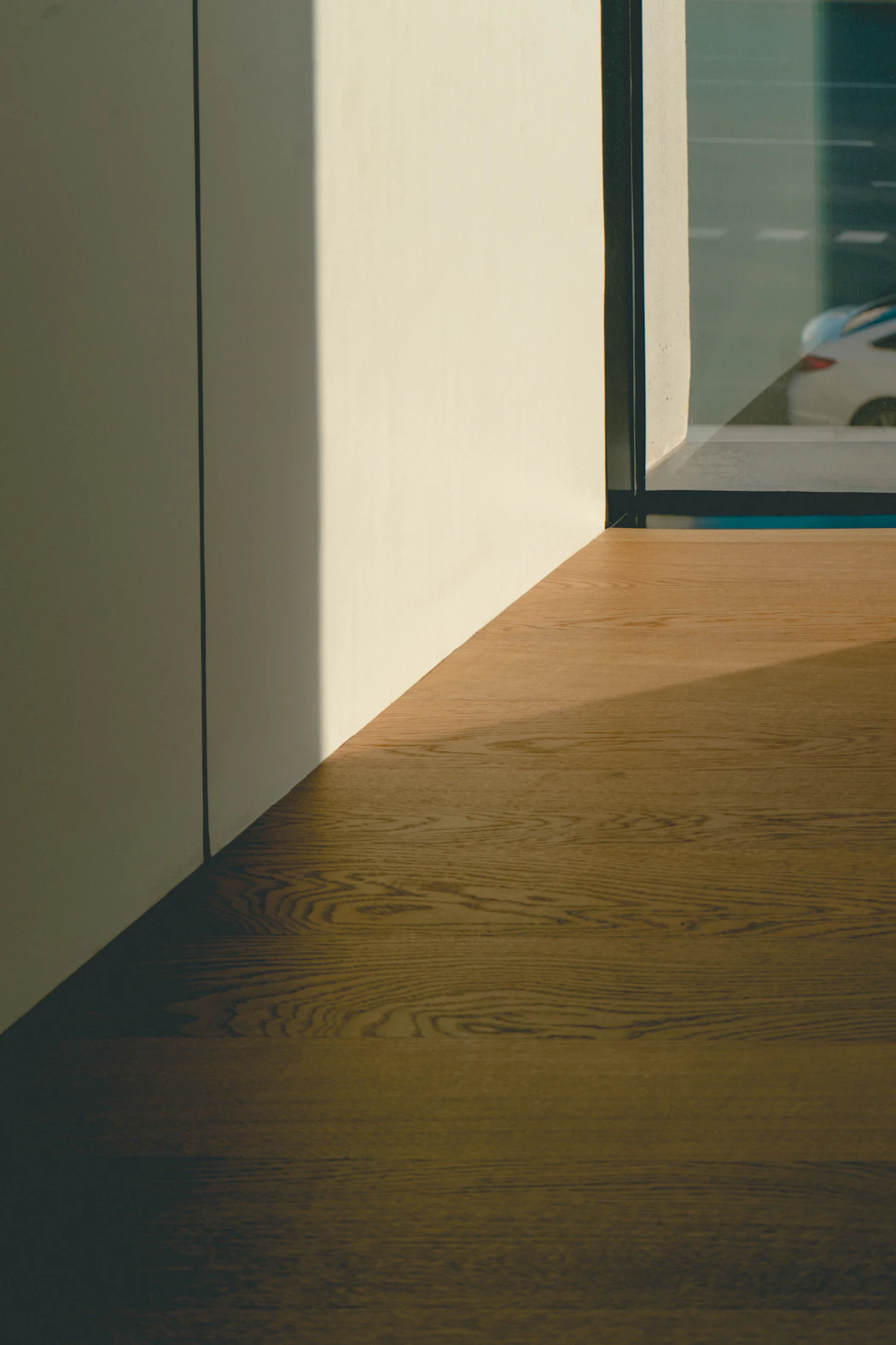 Pavimento de madera junto a la ventana de una vivienda, imagen ilustrativa de acabados