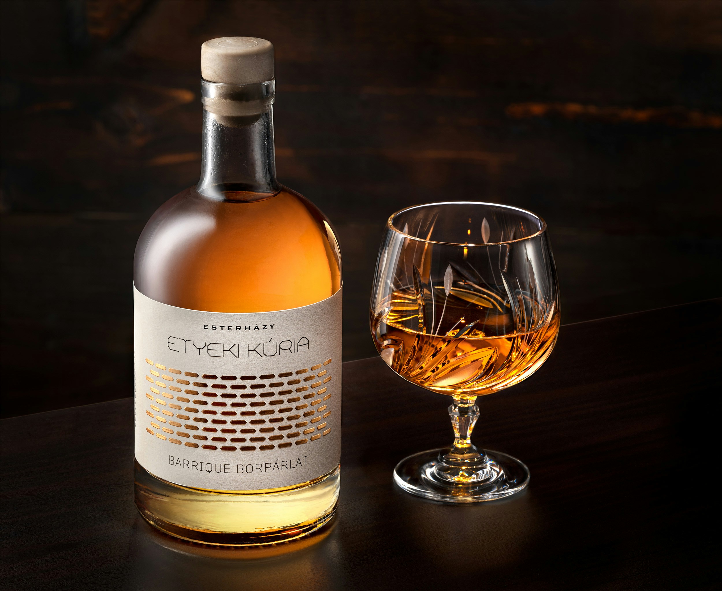 A bottle of alcohol next to a glass of alcohol