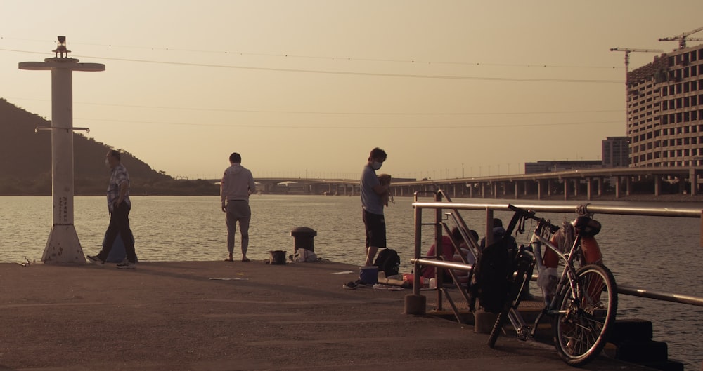 a group of people standing on a dock by the water