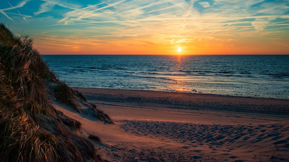 Une plage avec un coucher de soleil