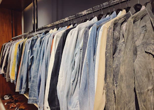 A row of embroidered work jackets hanging neatly on a rack.