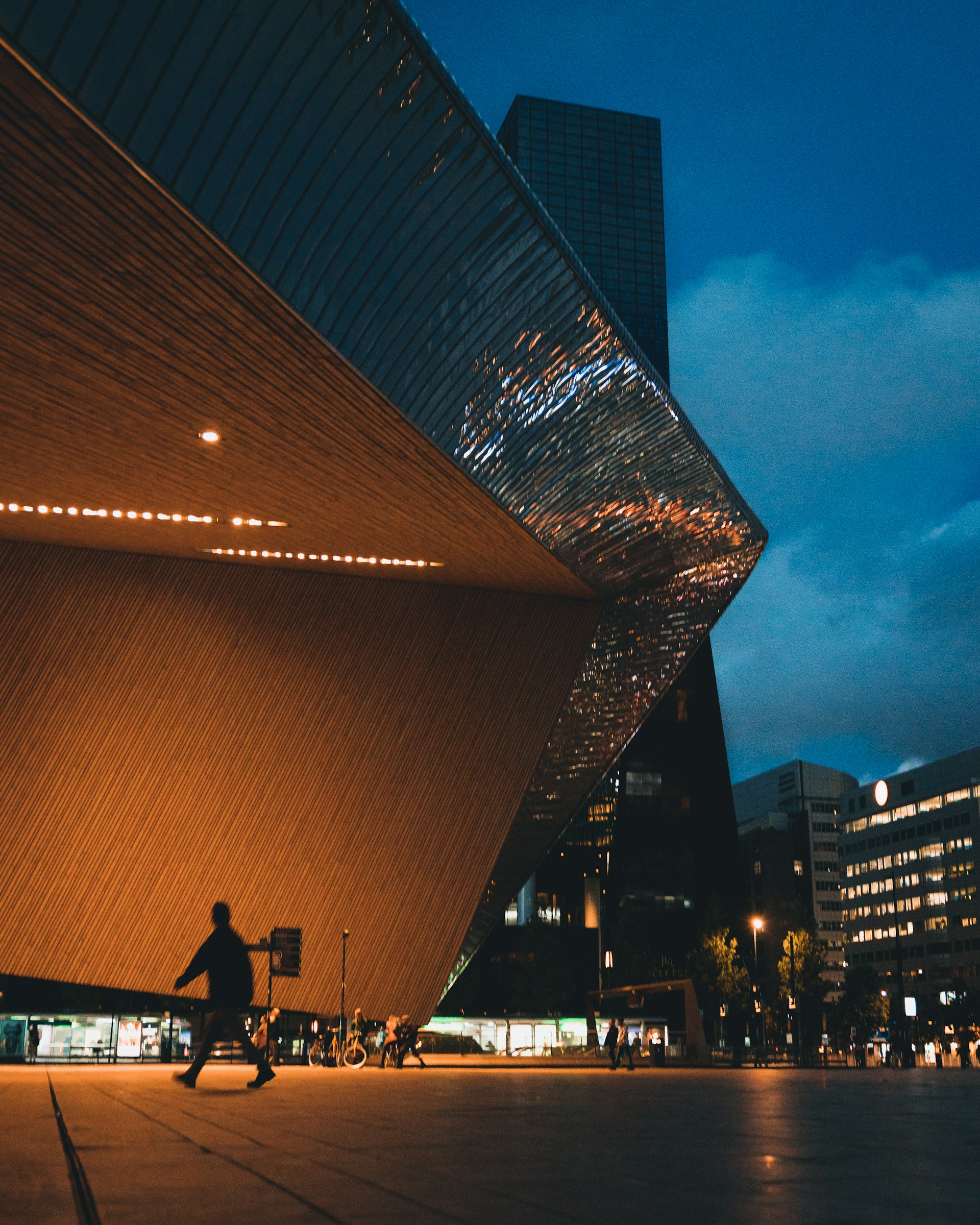 A sleek urban scene at dusk, featuring clean lines and reflections that emphasize modern European architecture.