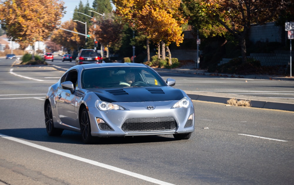 a silver car driving down the road