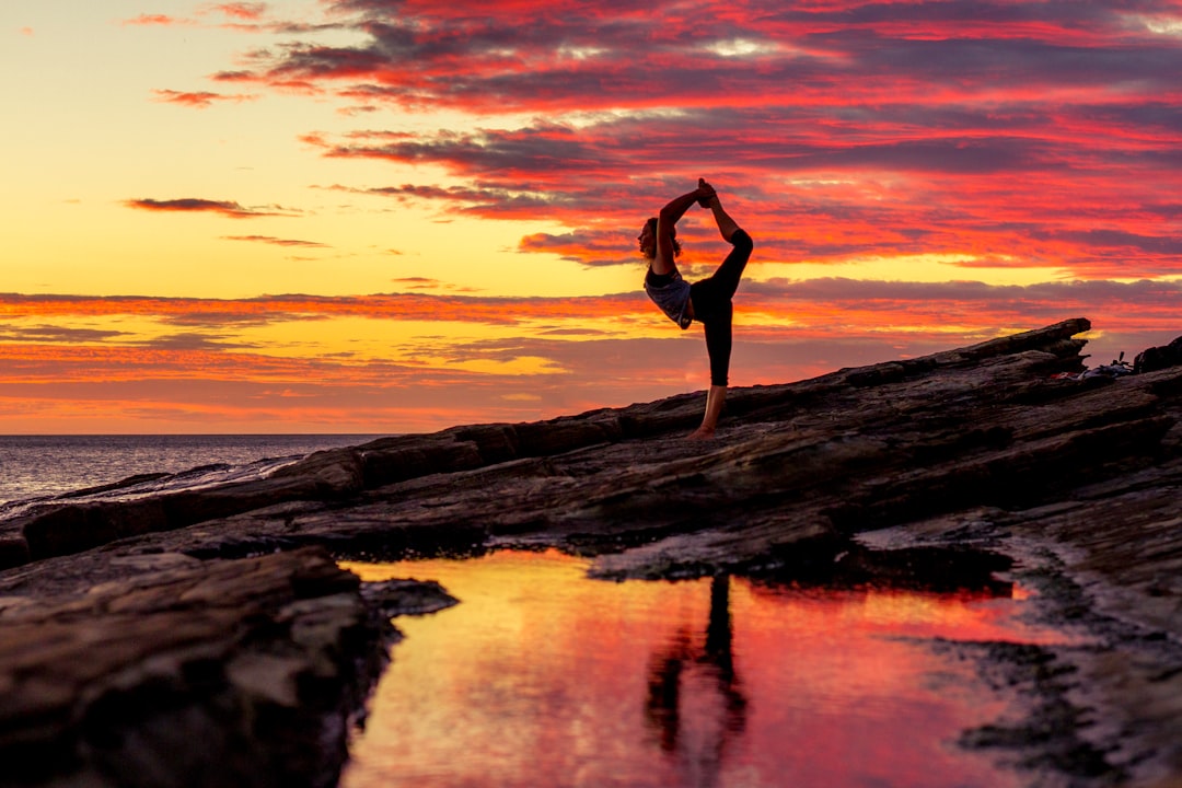 Girl striking a yoga pose during sunset on rocks in Nicaragua.