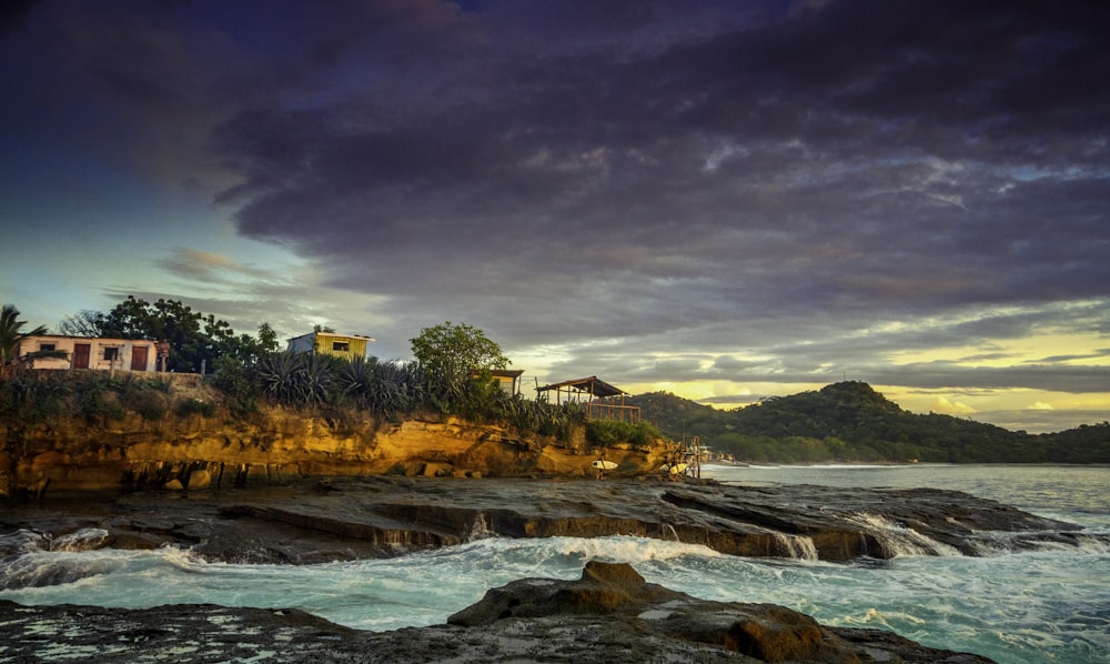 a rocky beach with a bridge and buildings in the background