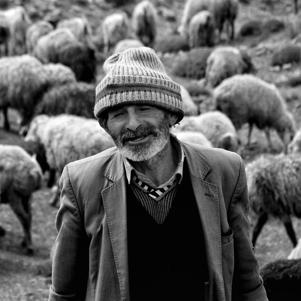 a man standing in front of a herd of sheep