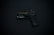 A black handgun with detailing and an attached flashlight is displayed against a dark background.