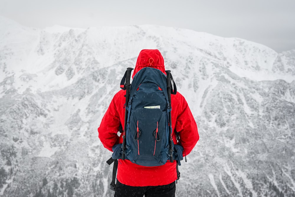 a person with a backpack walking on a snowy mountain