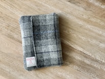 A collection of Harris Tweed bags displayed on a rustic wooden table.