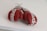 A pair of red boxing gloves with the brand names 'Supreme' and 'Everlast' are placed on a white surface. The gloves appear new and are tied together with a white cord.