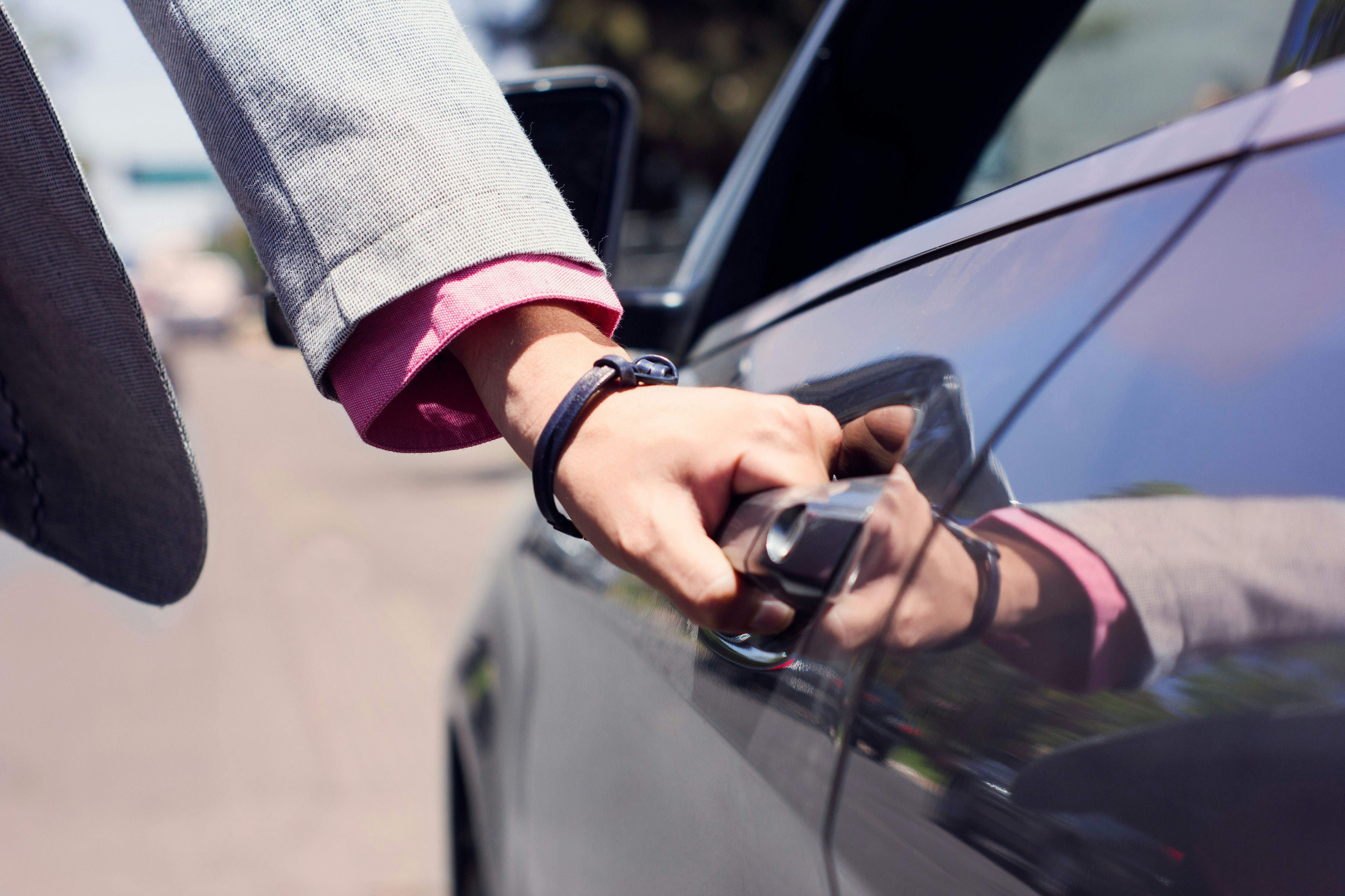 Tesla owner handing keys to a buyer in a parking lot