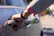 Customer shaking hands with a mechanic beside a shiny black car.