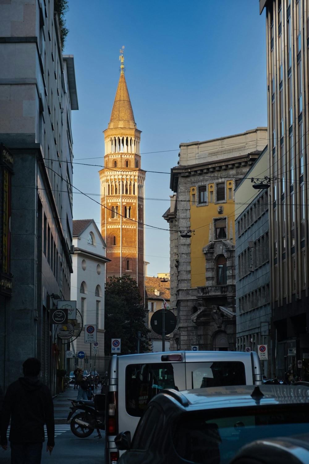 a city street with buildings and a tall tower in the background