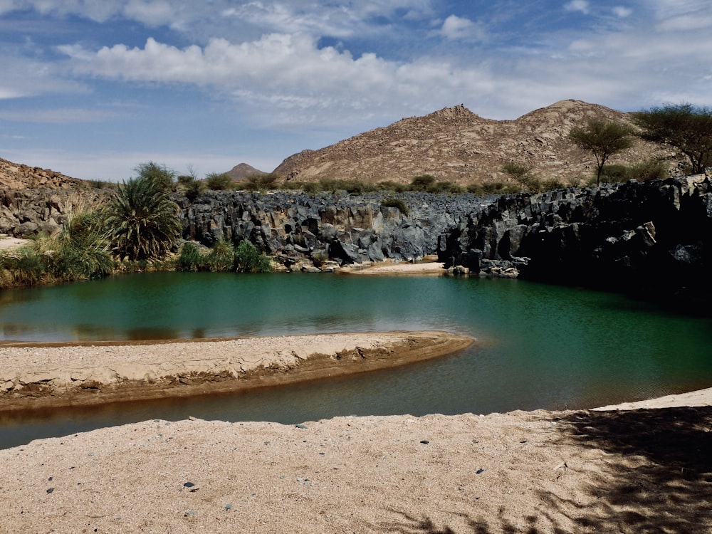 a body of water with a rocky cliff in the background