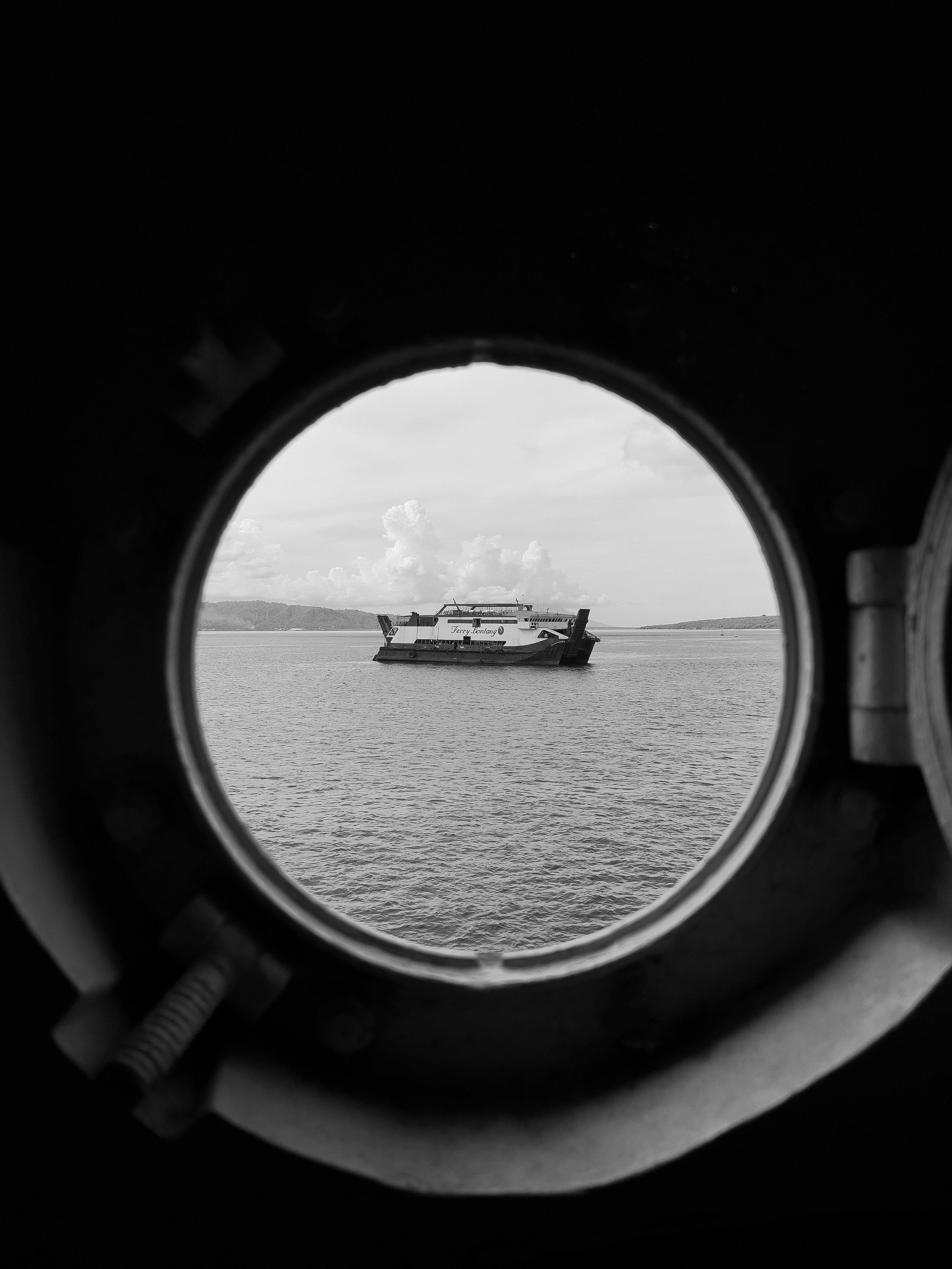 una vista di una barca fuori da una finestra di una nave sull'acqua