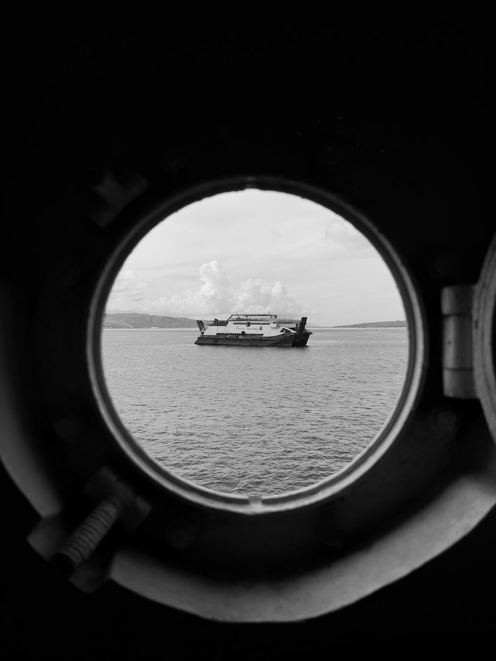 a view of a boat out a window of a ship on the water