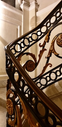 A detailed close-up of expert craftsmanship on a custom staircase railing made from rich wood and wrought iron.