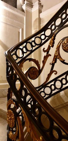 Close-up of a custom wrought iron railing with intricate detailing on a curved staircase.