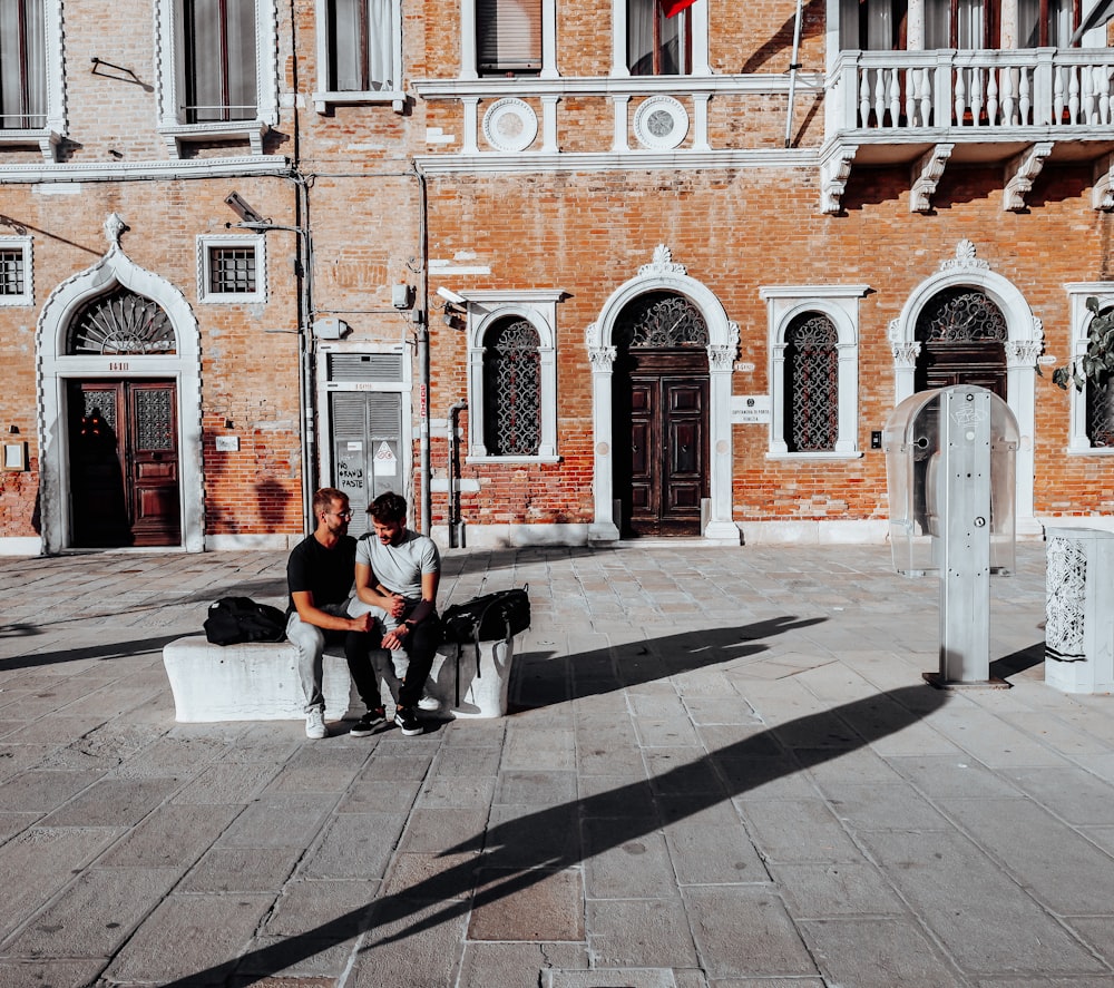 two men sitting on a bench