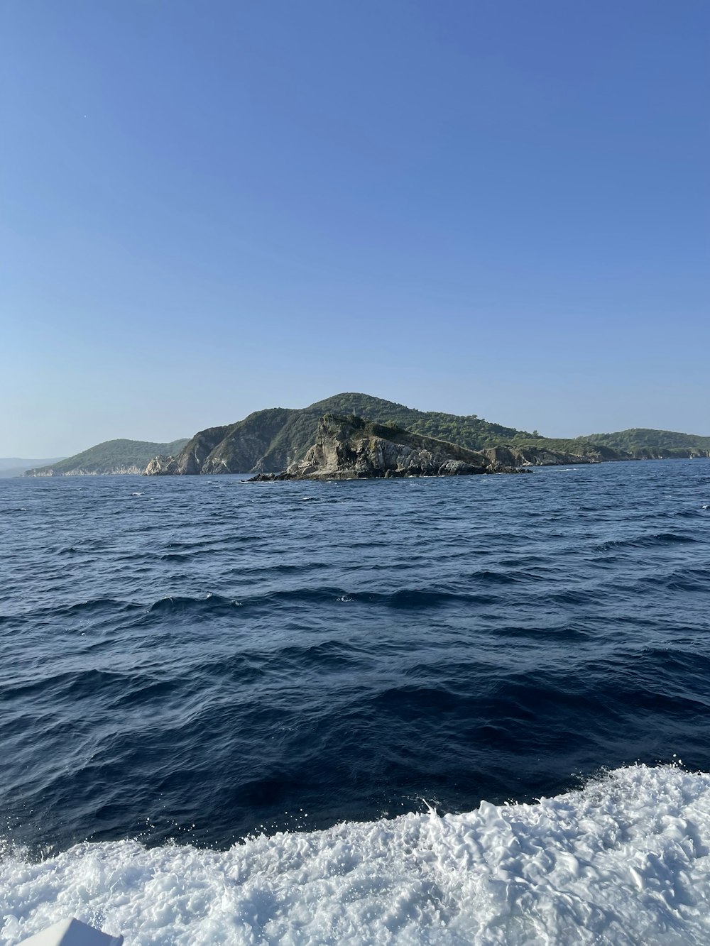 um corpo de água com uma ilha rochosa à distância