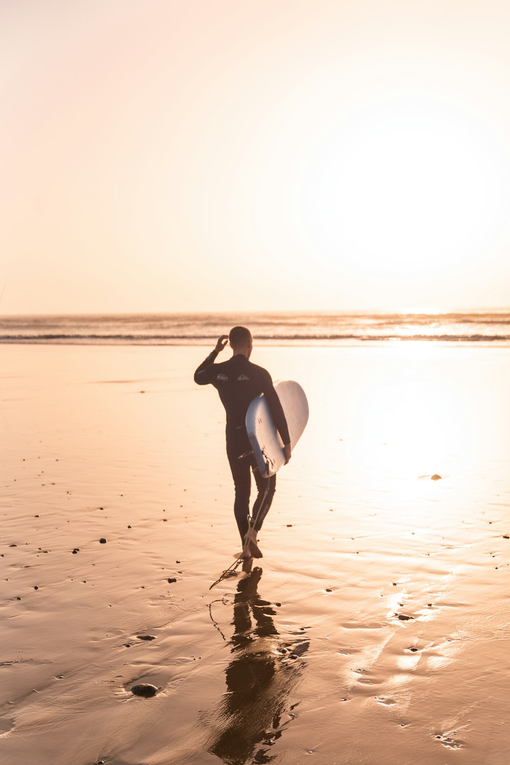 Un uomo che trasporta una tavola da surf su una spiaggia