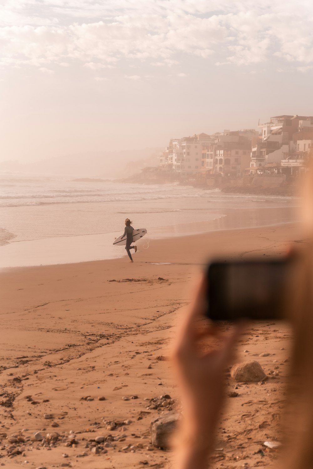 uma pessoa segura uma prancha de surf em uma praia