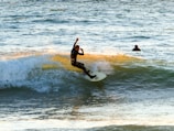 A surfer riding a wave at a beautiful Bali beach.