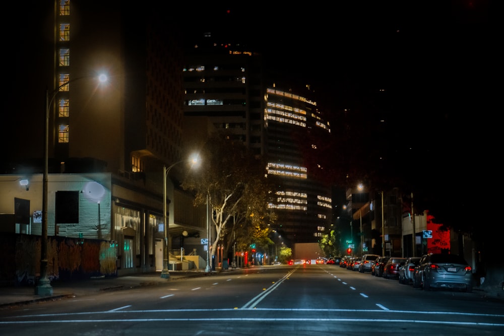 a street with cars and buildings at night