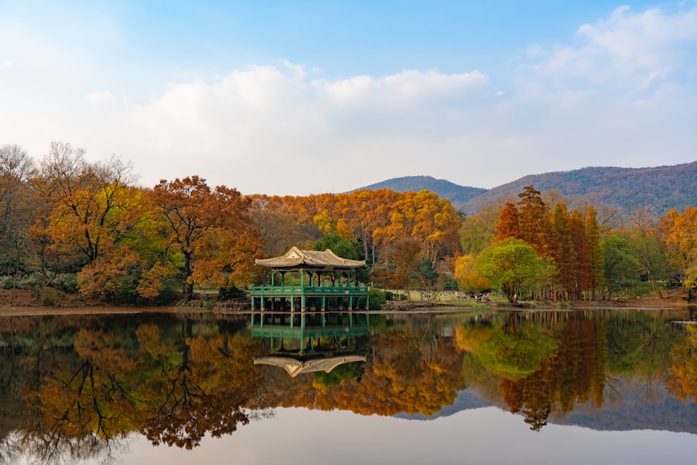 a building on a dock surrounded by water with trees and mountains in the background