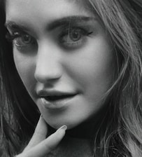 Black and white portrait of a person with expressive eyes and soft lighting.