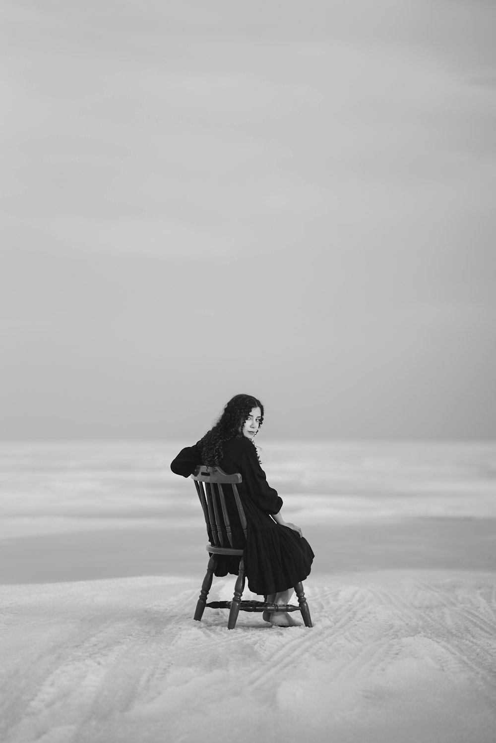 una persona seduta su una sedia nella neve