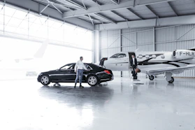 Luxury private jet set inside a bright hangar studio with panoramic windows