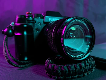 Close-up of a modern digital camera with a vibrant lens reflecting colorful surroundings.