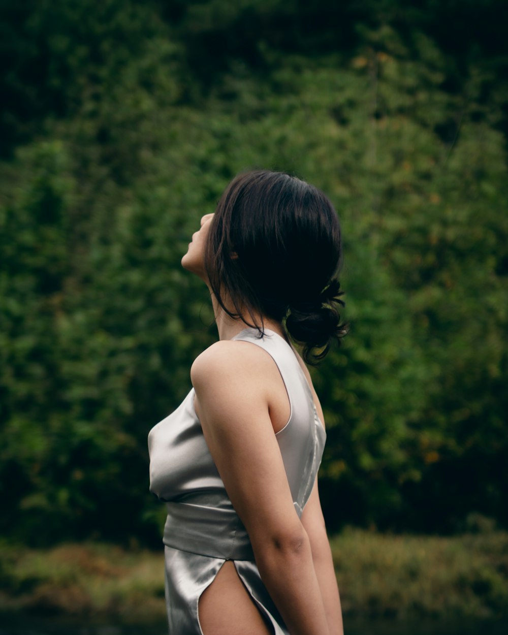 a woman with her hand on her head looking at the ground