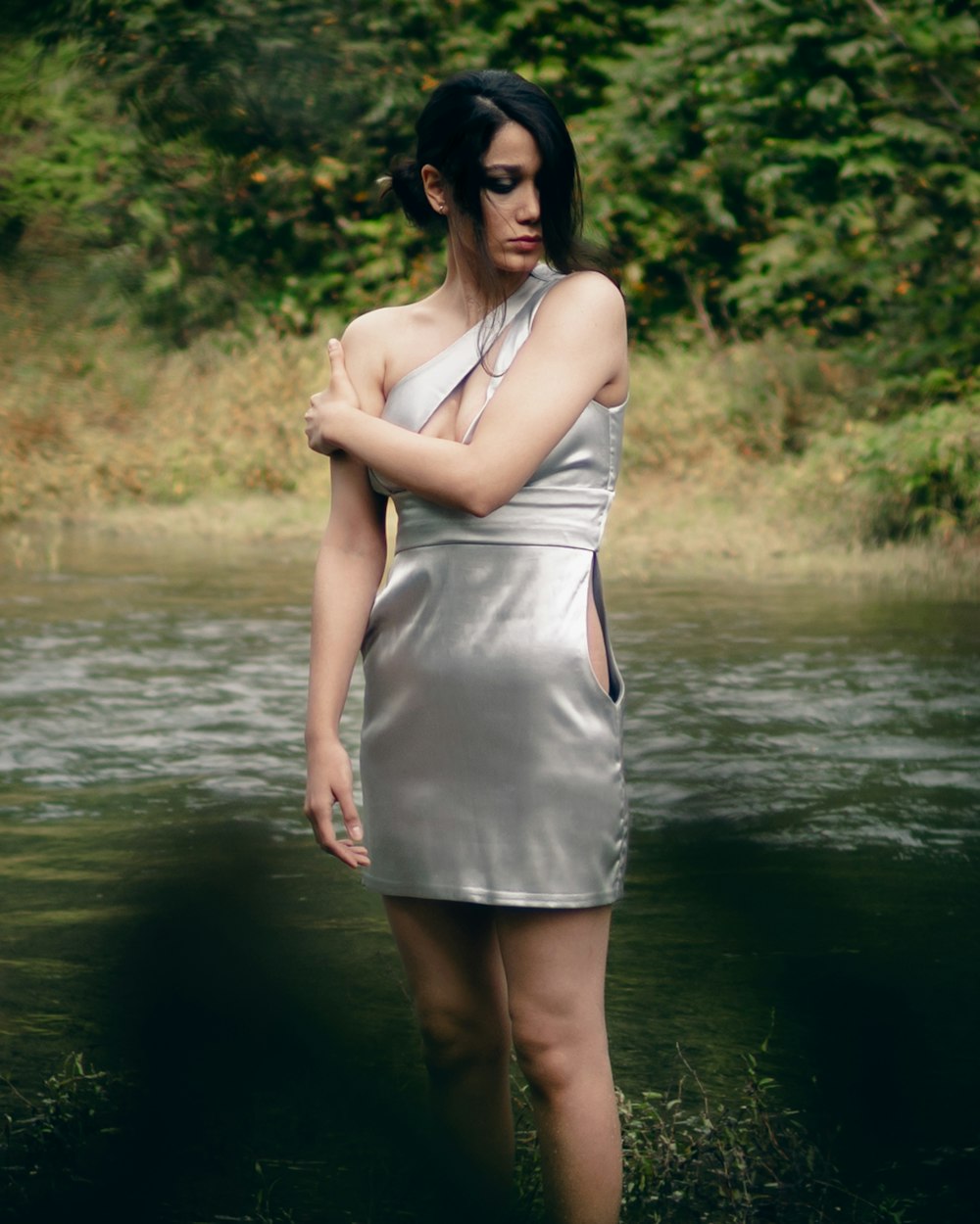 a woman standing in a body of water posing for the camera