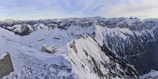 A panoramic view from a mountain lodge balcony with misty peaks in the distance.