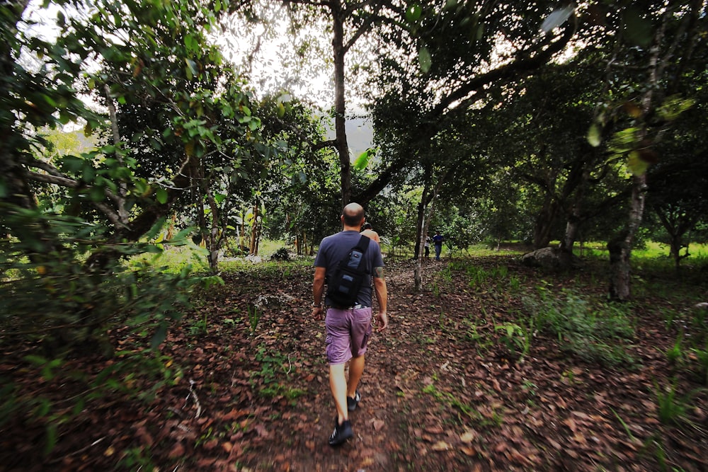 a man walking on a path in the woods