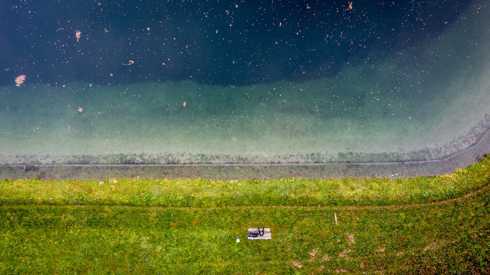 a field of grass with a fence and a field in the background