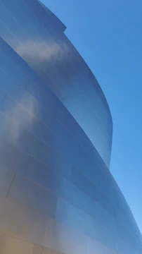 A sleek aluminum curtain wall gleaming under Qatar's sun on a modern commercial building.