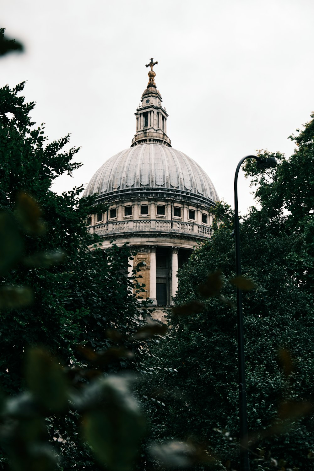 a domed building with a cross on top with Maryland State House in the background